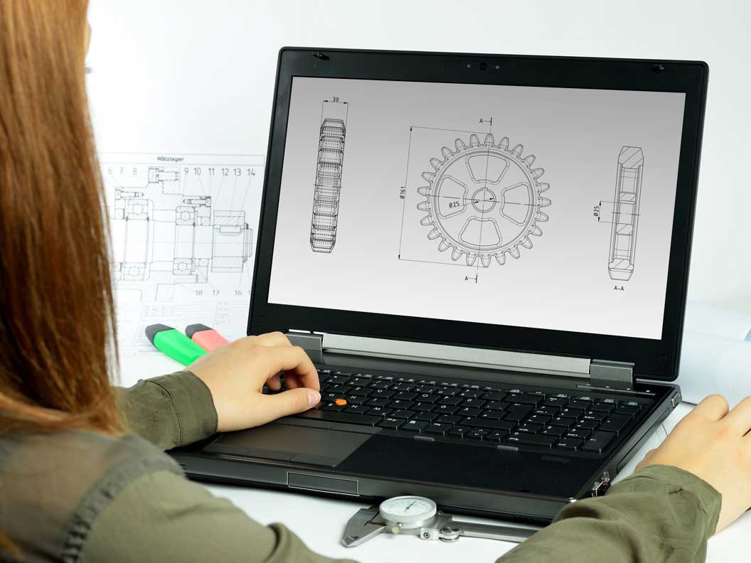 Female mechanical engineering technician using software to prepare layouts of parts to be made. 
