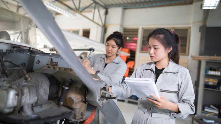 Female engineering technicians inspect products for flaws. 